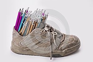 Stack of pens inserted to old wear out sneaker