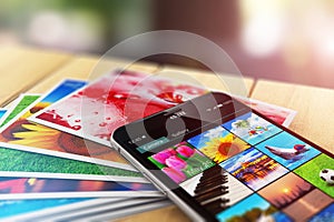 Stack of photos and smartphone with image gallery app