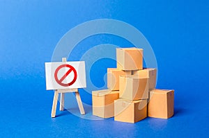 A stack pile cardboard boxes and a sign stand with red symbol NO. Restriction on the importation of goods, proprietary
