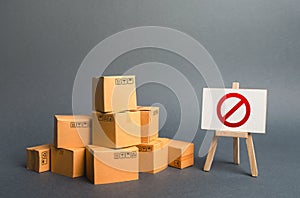A stack pile cardboard boxes and a sign stand with red symbol NO. Restriction on the importation of goods, proprietary photo