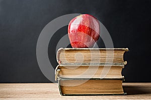 Stack Pile of Old Books Red Glossy Apple on Top. Learning Education Knowledge Concept. Blackboard Background. Classrom.