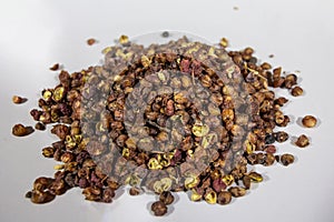 Stack and pile of Sichuan pepper on a white background. it\'s chinese spice called Szechuan pepper, Szechwan