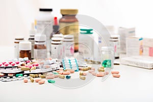 Stack of pills and containers on white background