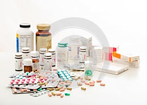 Stack of pills and containers on white background