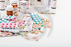 Stack of pills and containers on white background