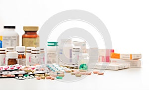 Stack of pills and containers on white background