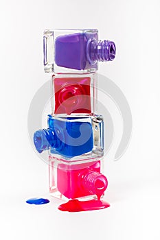 Stack of pink and blue nail polish isolated on white background