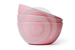 A stack of pink plastic plates on a white background.