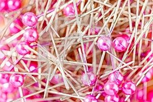 Stack of pink sewing pins in the box.