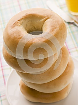 Stack of Plain Bagels with a Glass of Orange Juice