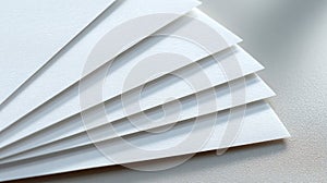 Stack of plain white textured paper sheets creating an abstract pattern on light surface, copy space