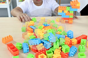 Stack of plastic colorful toy brick block toys for children on top of table, piece for bricks toy lego with kid hands, decorative