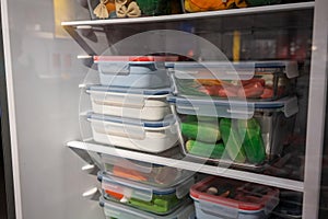 Stack of plastic containers in refrigerator for display