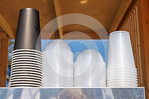 A stack of plastic cups on a metal shelf