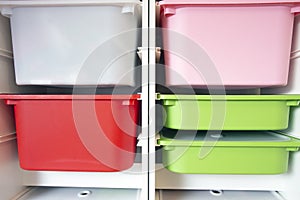 Stack of plastic storage boxes in different colors, sorting system arrangement