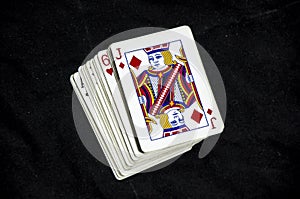 A stack of playing cards with a jack showing