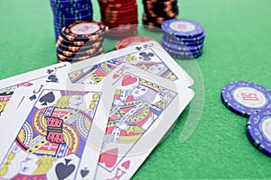 Stack of poker chips and cards on a green game table