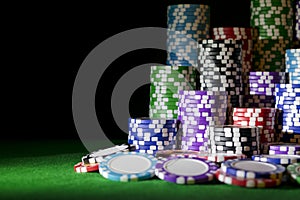 Stack of Poker chips on a green gaming poker table with poker dice at the casino . Playing a game with dice. Casino dice Concept