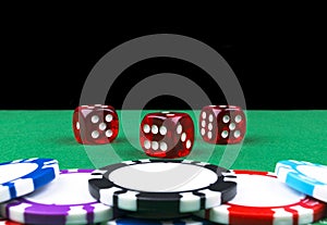 Stack of Poker chips on a green gaming poker table with poker dice at the casino . Playing a game with dice. Casino dice Concept