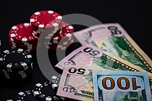 Stack of poker chips, money and playing card on a dark surface