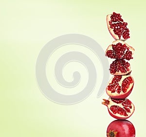 Stack of pomegranate fruits on honey dew gradient background, space for text