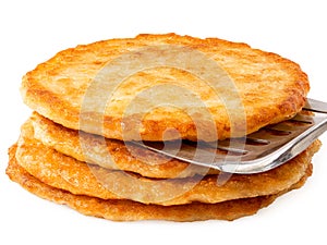 Stack of potato pancakes with spatula isolated on white