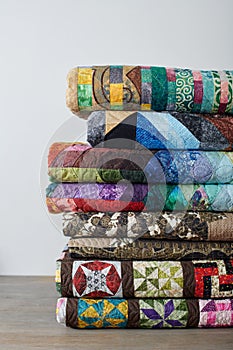 Stack of quilts on white wall background