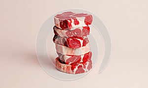 Stack of Raw Beef Steaks on Neutral Background