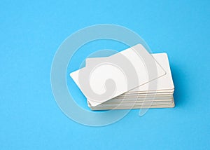 Stack of rectangular white blank business cards on a blue background