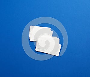 Stack of rectangular white blank business cards on a blue background
