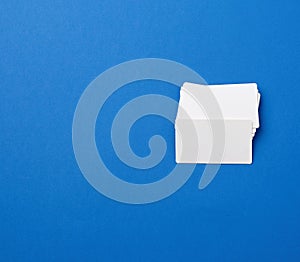 Stack of rectangular white blank business cards on a blue background