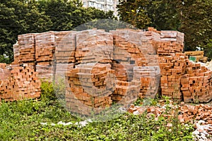 Stack of red brick for construction. Common quality building bricks stacked ready for use.