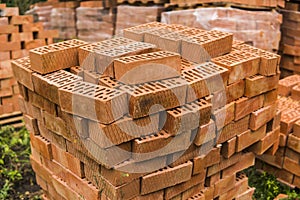 Stack of red brick for construction. Common quality building bricks stacked ready for use.