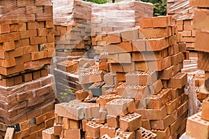 Stack of red brick for construction. Common quality building bricks stacked ready for use.