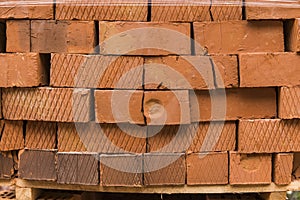 Stack of red brick for construction. Common quality building bricks stacked ready for use.