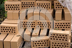 A stack of red bricks on a white background with a pointing trowel