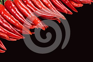 Stack of Red hot chilli pepper isolated on black background.