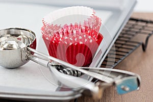 Stack of red theme cupcake liner with scoop, preparing for party.