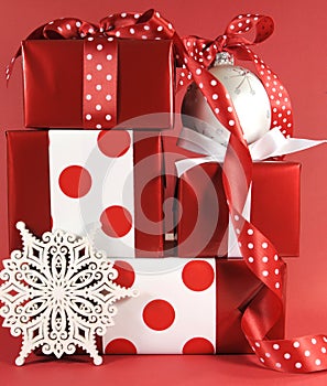 Stack of red and white polka dot theme festive gift box presents with ornaments