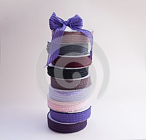A stack of reels with multi-colored reps ribbons for decoration and packaging of gifts and bouquets with bow