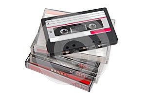 Stack of retro audio cassettes with one on top, angled and uncovered, on white back photo