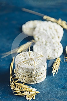 Stack of rice cakes. American puffed rice cakes. Healthy snacks with ears of wheat on classic blue concrete surface