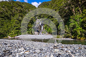 Stack of rocks and Fantail Falls at Mt Aspiring National Park, New Zealand.