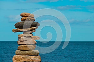 Stack of rocks. Stone tower with ocean blur in background