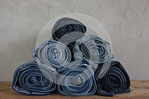 Stack roll blue denim jeans on wood