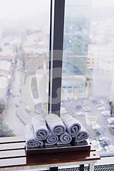 Stack of rolled towels in hotel at gym with city view