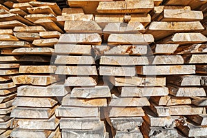Stack of rough wooden boards in lumberyard