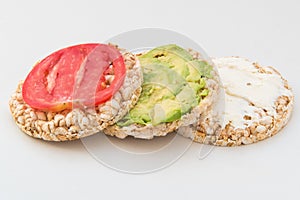 Stack of round crispbreads with cheese, tomatoes, avocado and basil