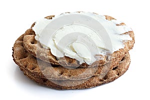 Stack of round rye crispbreads isolated on white. Top one spread