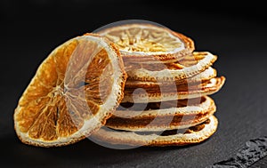 a stack of round slices of dried orange on a black background